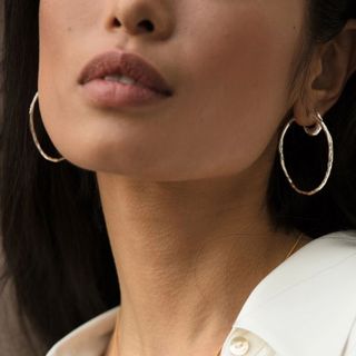 Image of woman wearing silver hoop earrings