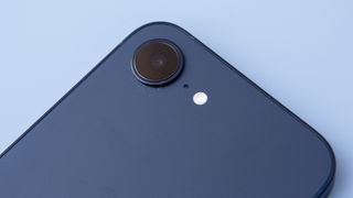 iPhone 16e in black on blue background