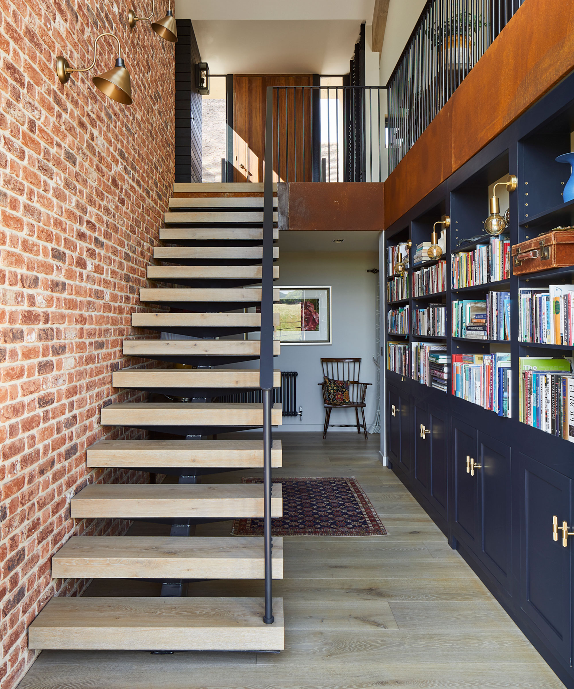 entrance hallway with modern open tread staircase and fitted blue furniture