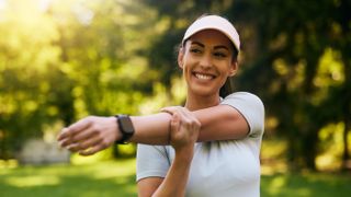 a woman stretching wearing a running watch