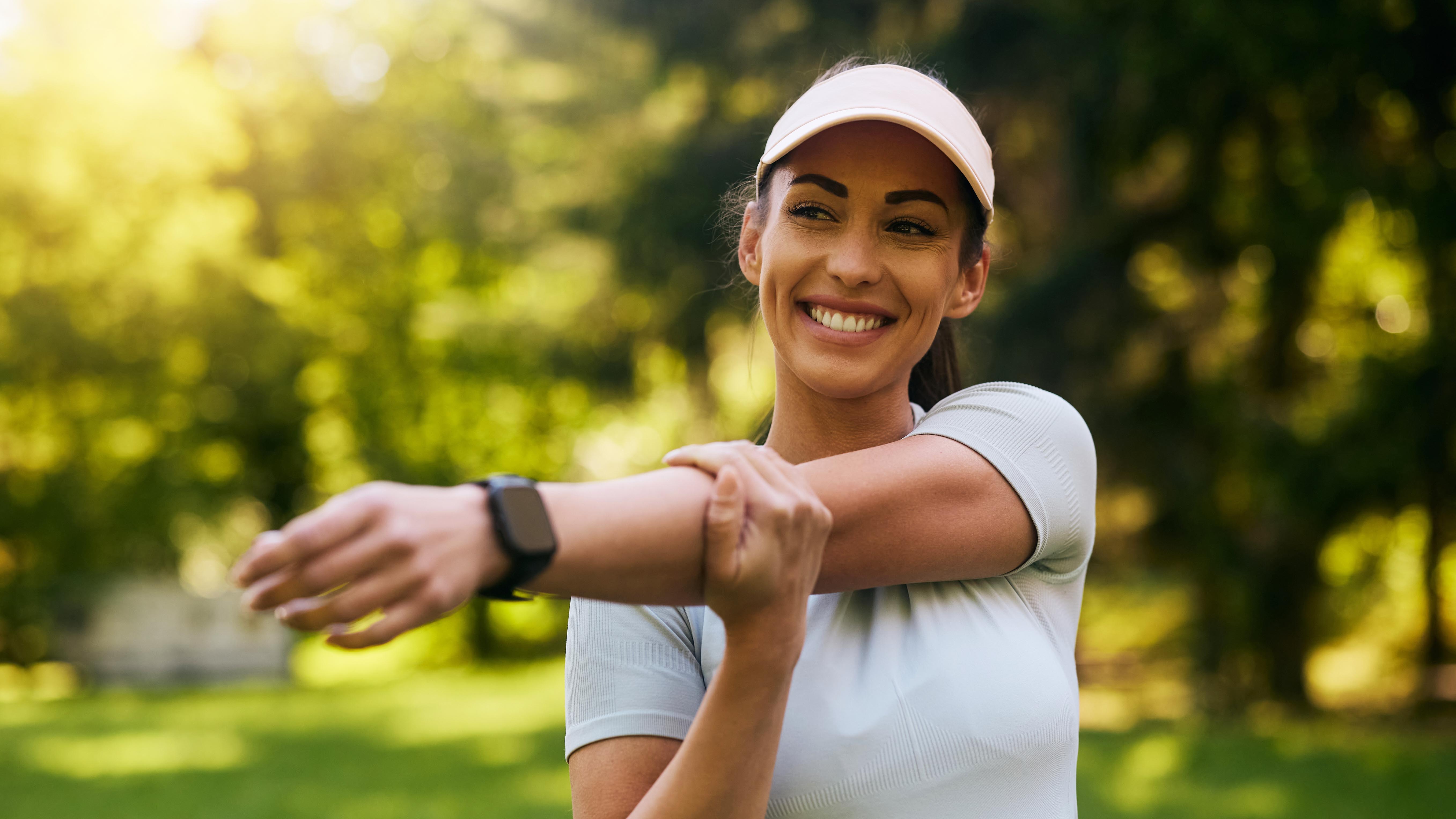 a woman stretching wearing a running watch