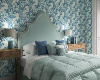 Blue bed with blue patterned wallpaper