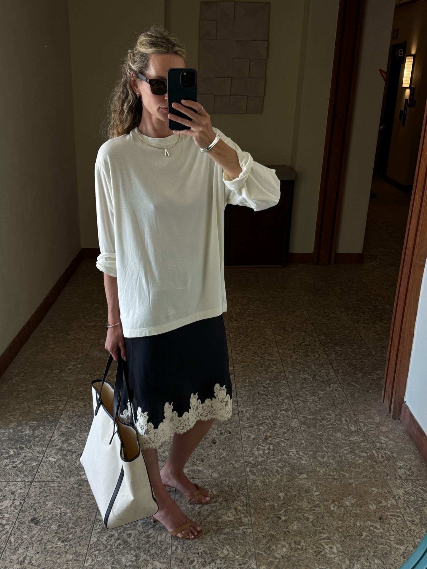 Woman in a white long sleeve tee and slip skirt.