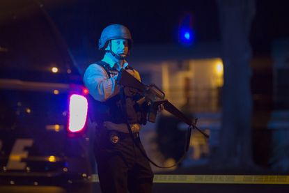 A police officer stands guard outside an apartment in San Bernardino, California