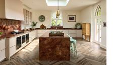 brass and cream kitchen with kitchen island and herringbone flooring
