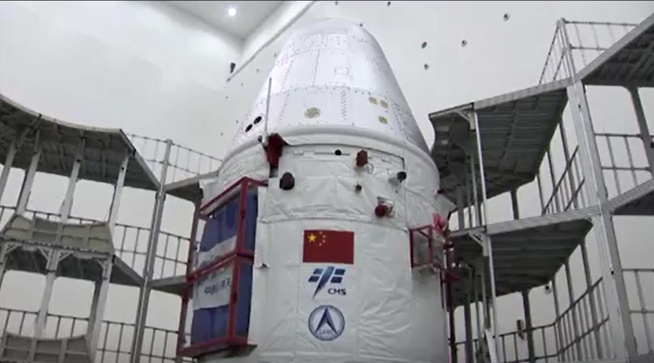 China's next-generation space capsule for astronauts is prepared for its uncrewed test flight on a Long March 5B rocket in these stills from a CCTV state news video. The capsule launched May 5, 2020.
