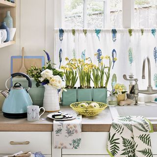 kitchen with kettle white flower vase and sink