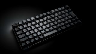 Realforce Topre RC1 wireless compact keyboard on a black background with grey keycaps.