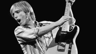 Tom Petty playing guitar onstage in 1981