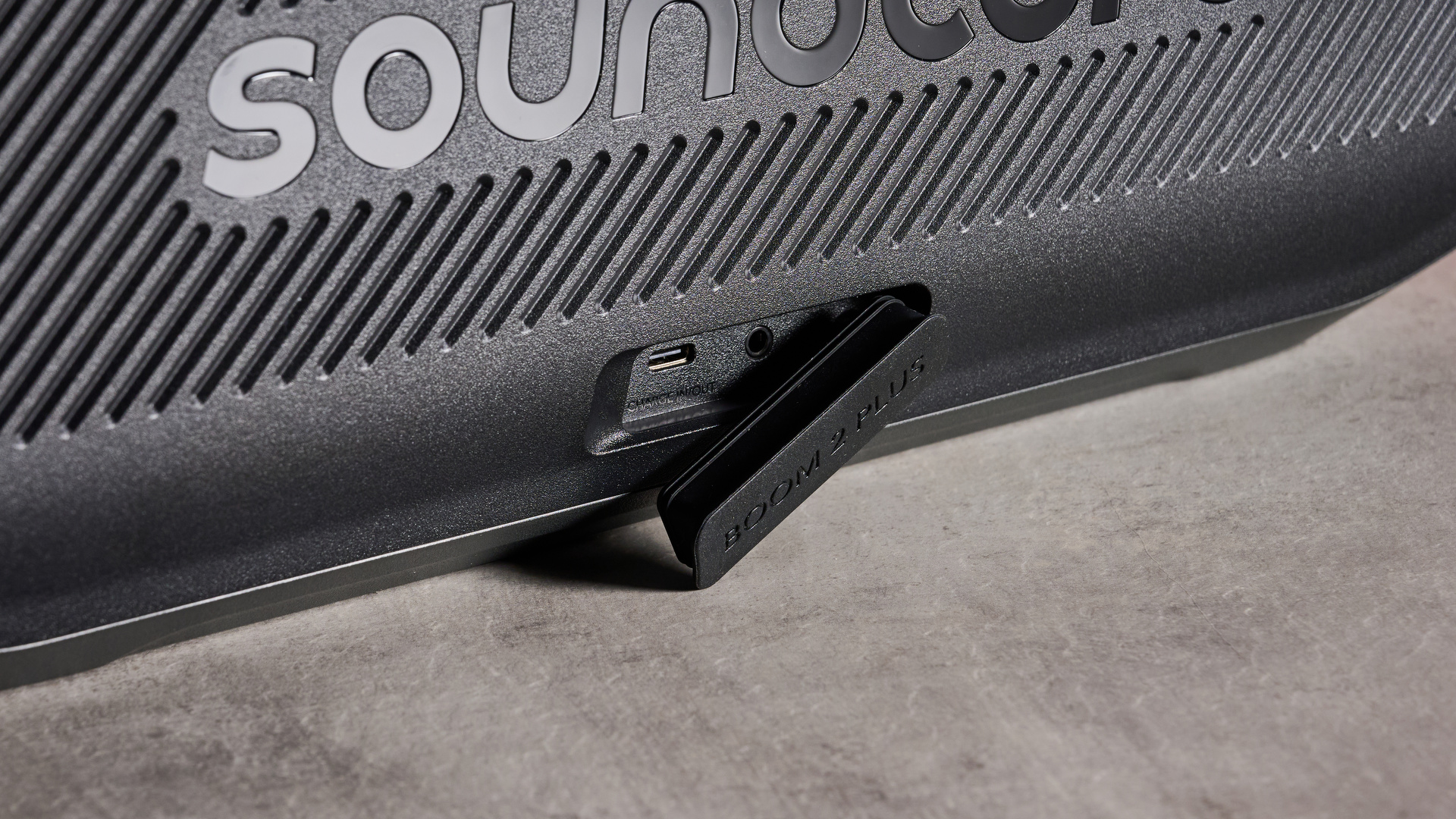 Rubber tab open to expose USB-C and AUX ports on the Anker Soundcore Boom 2 Plus