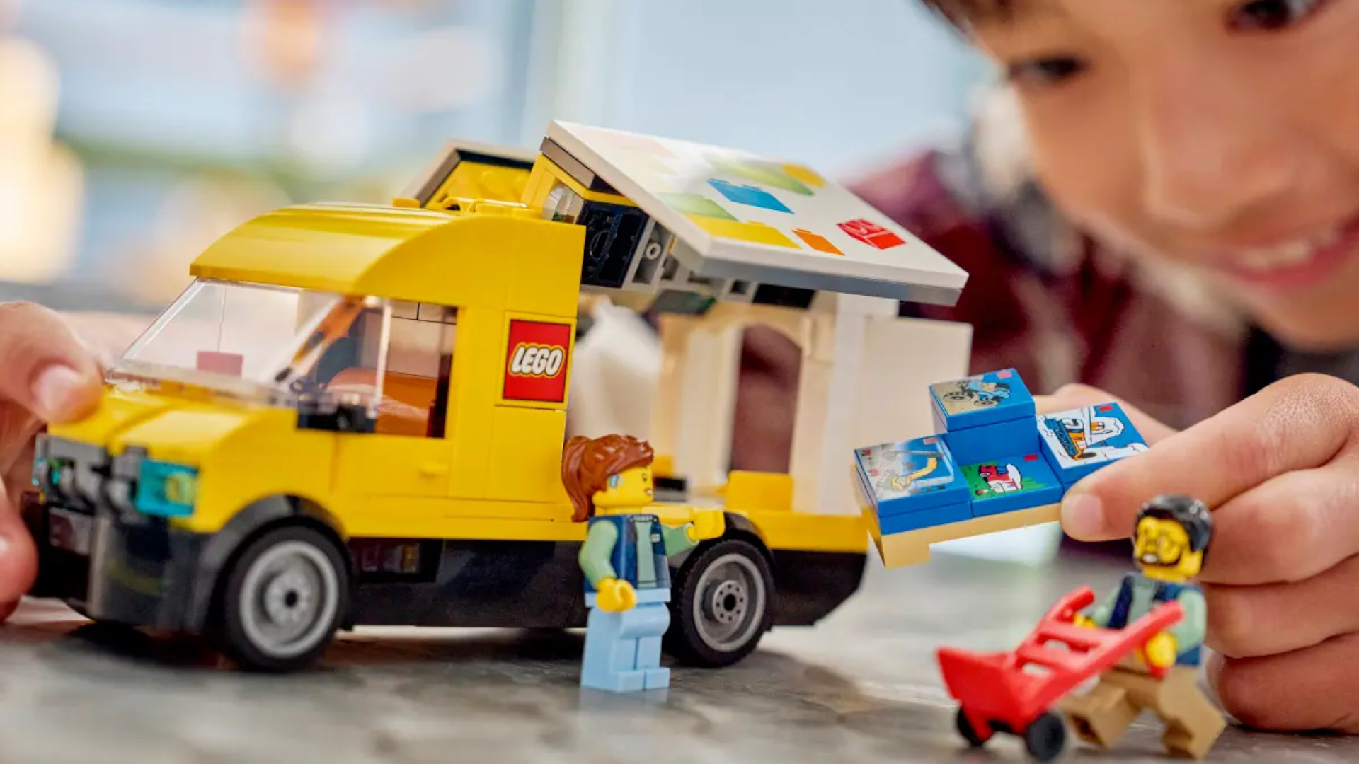 A child plays with the Lego Van set on a granite surface