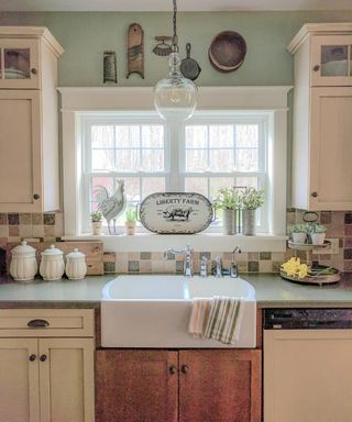 Farmhouse kitchen with vintage kitchenalia displayed on wall above large ceramic sink.