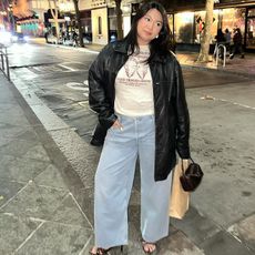 Marina wears white t-shirt, leather jacket, jeans, and a little heel. 