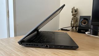 Side profile of open Asus TUF A15 gaming laptop on wooden table