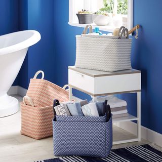 bathroom with blue wall and multi coloured fabric baskets