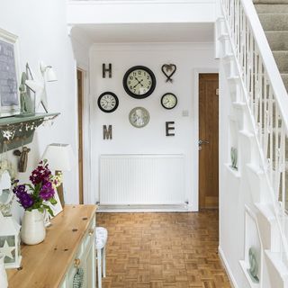 hallway with white wall and carpet on flooring with clock on wall