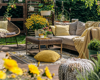 Small backyard patio space with planting, coffee table and outdoor seating