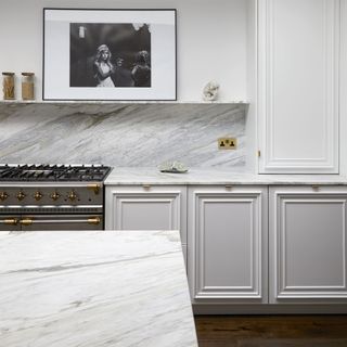 Light grey kitchen with shaker ucpboards and marble countertops.