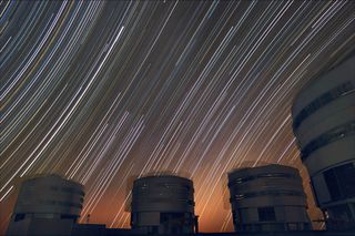 The sky appears to rotate above ESO's Very Large Telescope in this long exposure. The star trails curve away from the celestial equator in the middle of the photo, where the stars seem to move in a straight line.