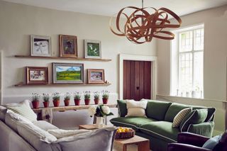 living room with cream and green sofa and bentwood light fitting with a row of lavender in terracotta pots