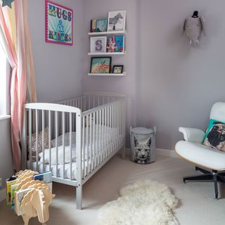 Lilac grey nursery with faux sheepskin rug and wooden sheep book holder
