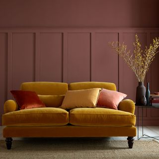 living room with burgandy coloured wall and yellow sofa