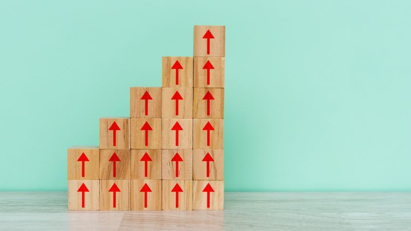 Stack of wooden blocks with upward arrows on