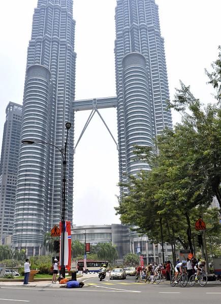 The peloton passes the Petronas towers.