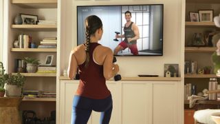 Peloton Digital review: A woman works out with dumbbells in a Peloton strength training class