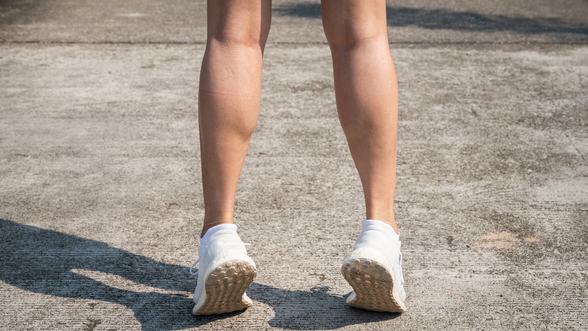 View of a woman&#039;s lower legs performing a calf raise