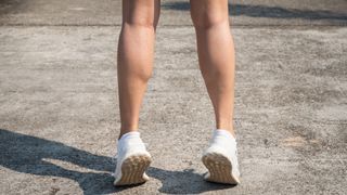 View of a woman's lower legs performing a calf raise