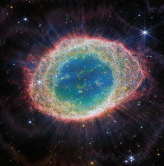 The Ring Nebula glows with rainbow-colored light against a black background of space