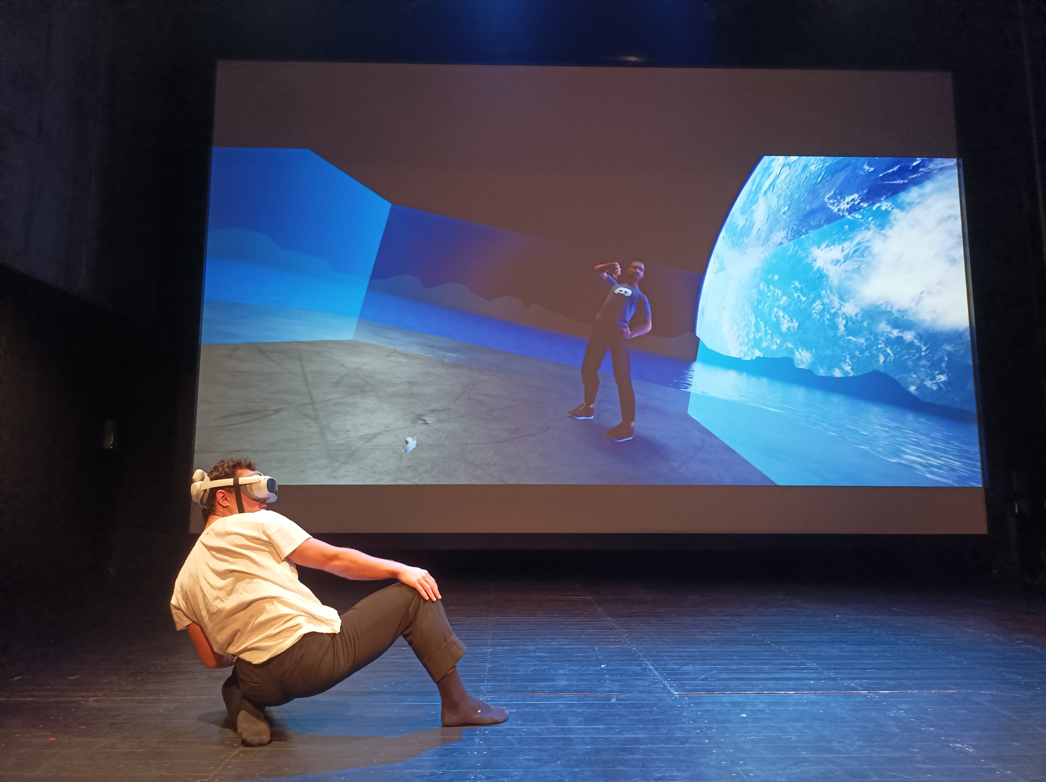 People dancing wearing black in front of a screen
