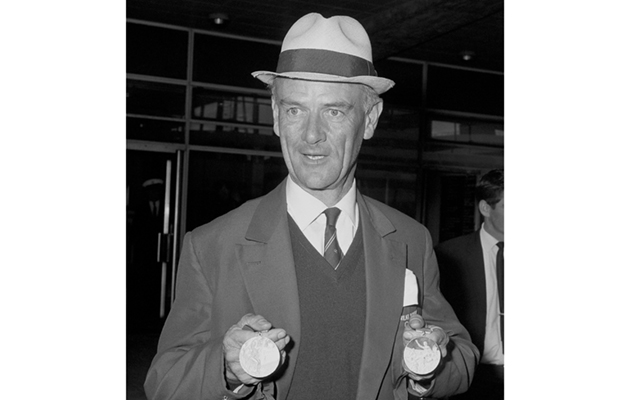 Major Derek Allhusen shows off his gold medal for Great Britain's equestrian team and his own individual silver medal, on arrival at Heathrow Airport.