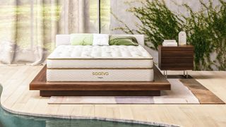 The Saatva Classic mattress photographed in a stylish white pool room with an indoor river