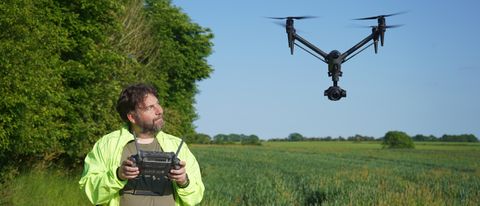 Adam Juniper piloting the DJI Inspire 3 which is near him in a field as part of the DJI Inspire 3 review testing process