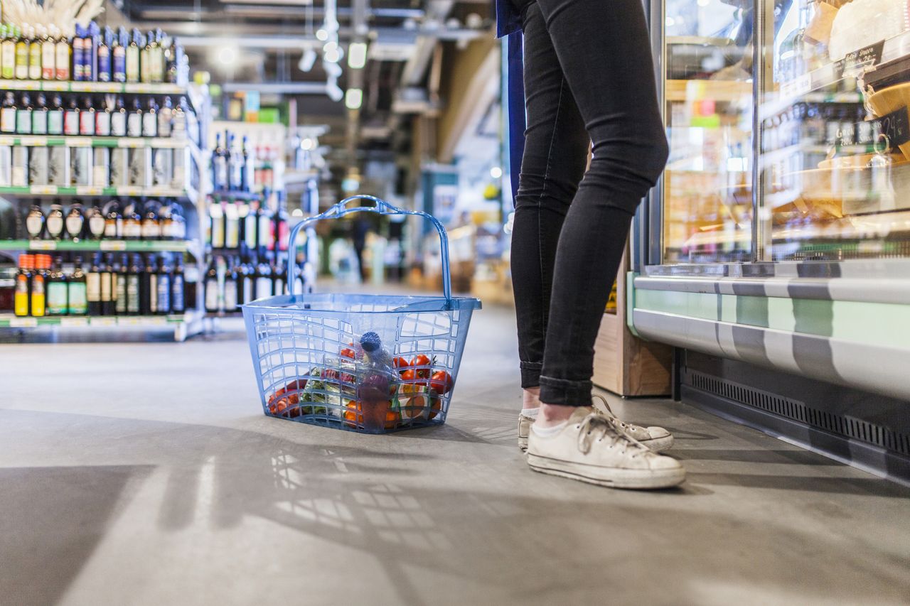 Woman with shopping basket in supermarket