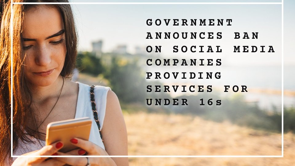 A close-up of a young woman looking down at her smartphone, overlaid with text in a stylized window box that reads "GOVERNMENT ANNOUNCES BAN ON SOCIAL MEDIA COMPANIES PROVIDING SERVICES FOR UNDER 16s."