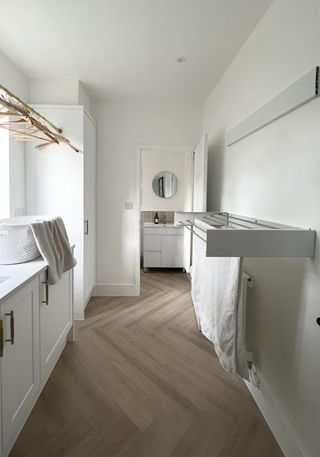 A white laundry room with two wall-mounted clothes airers