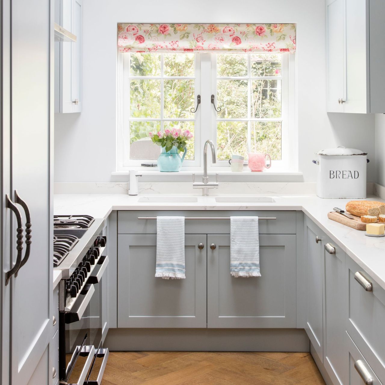 White painted galley kitchen with grey cabinets and a white worktop
