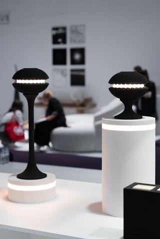 small black lamps on white display stands