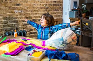 Boy looking super excited making paper mache