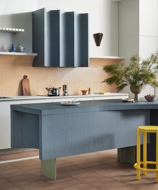 modern kitchen with blue island and extractor hood