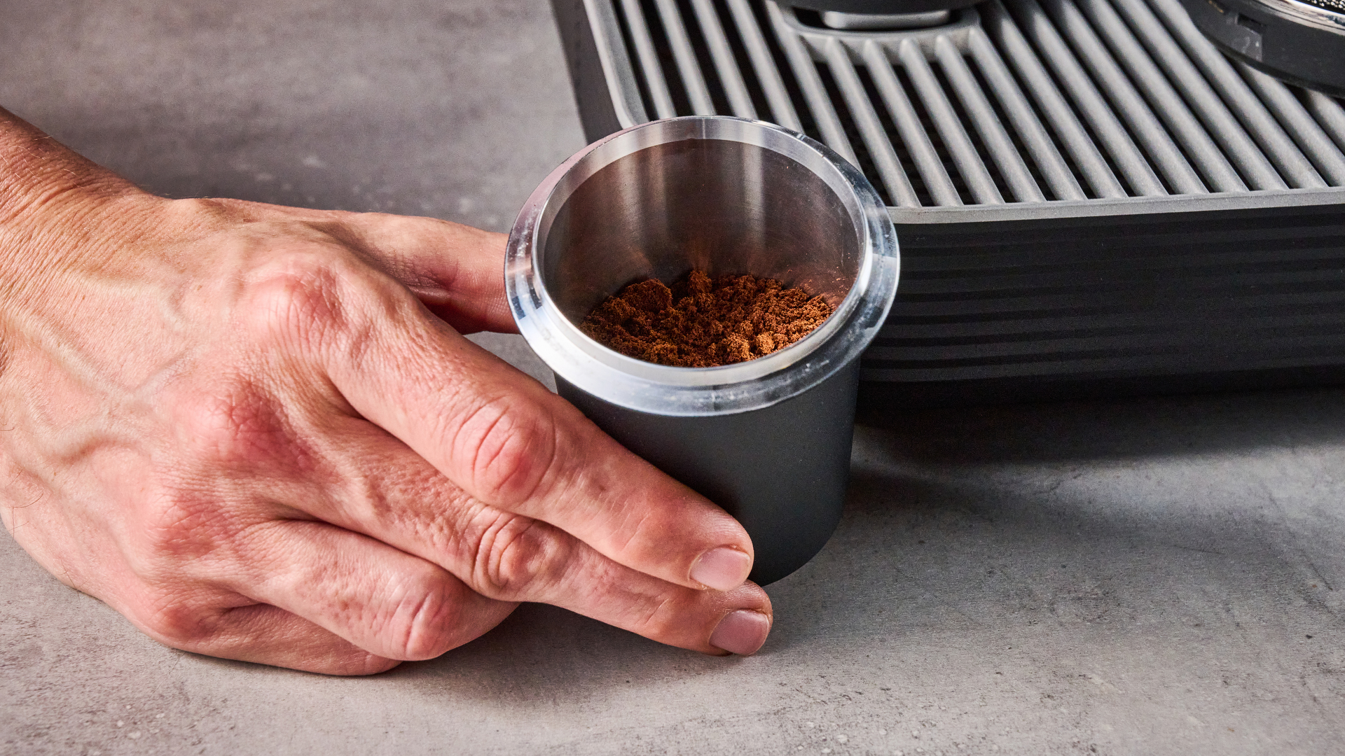 The Meraki Espresso Machine dosing cup full of fine grounds.