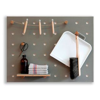 white wall with brush and cleaning cloth with peg board