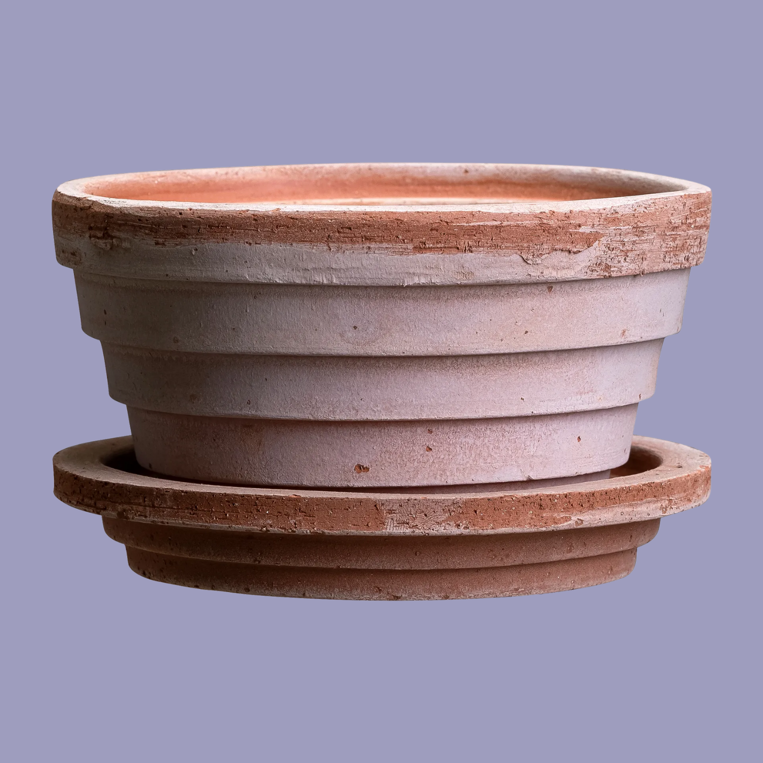 A ridged terracotta pot and saucer