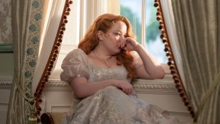 Penelope sitting by a window leaning against her arm in Season 3 of Bridgerton.