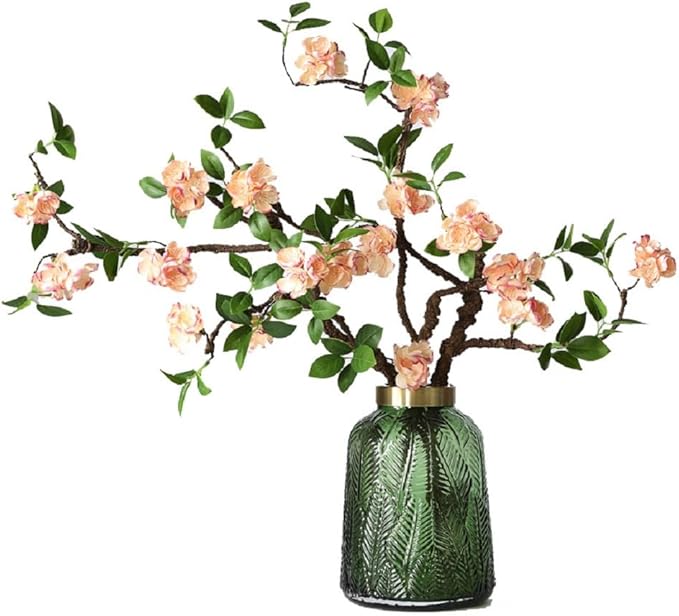 Faux cherry branches with flowers and leaves in a vase