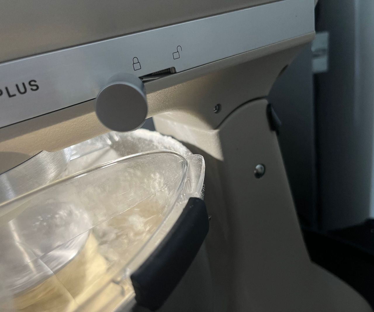 A close up of some spilled flour on the back rim of the KitchenAid Artisan Plus Stand Mixer