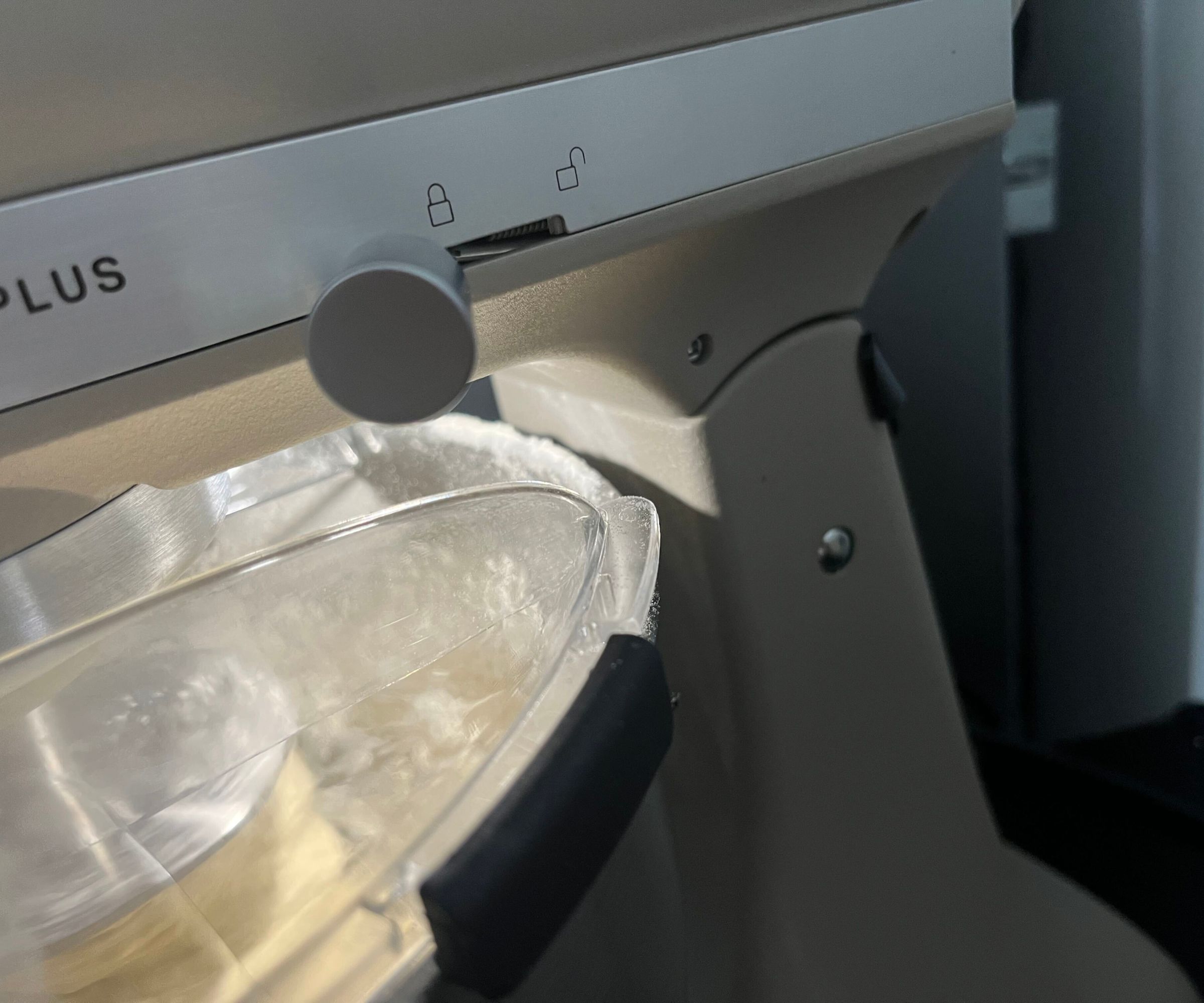 A close up of some spilled flour on the back rim of the KitchenAid Artisan Plus Stand Mixer